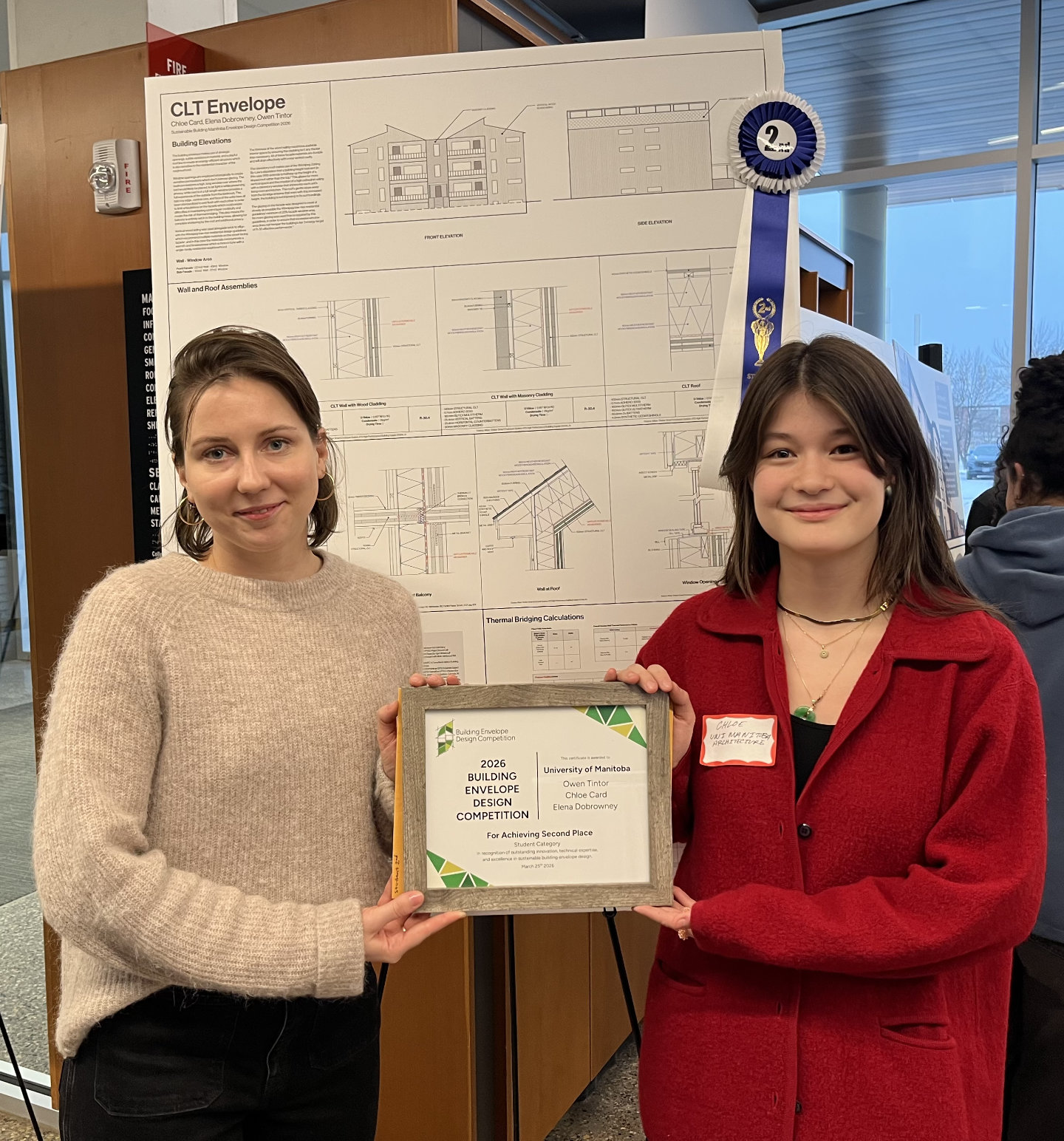 University of Manitoba students, Chloe Tintor and Elena Dobrowney, stand in front of their winning poster. They are holding their frames second place certificate.